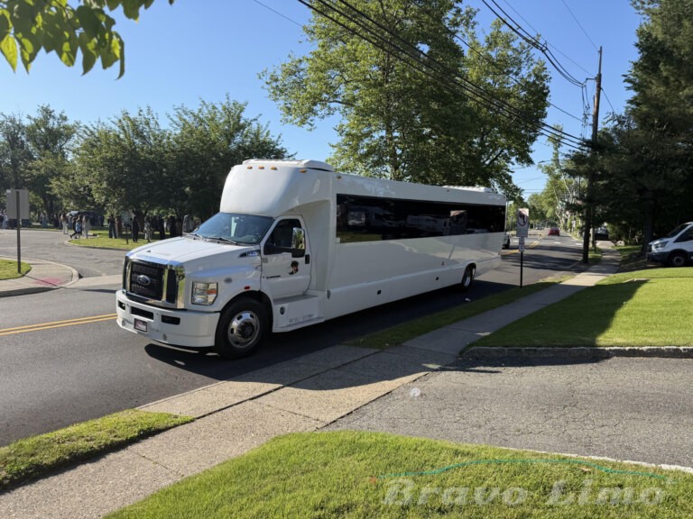 White luxury transformer party bus parked on a sunny street.