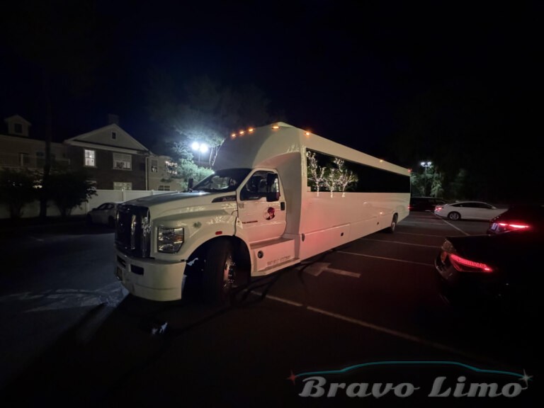 White luxury Transformer party bus at night with Bravo Limo branding