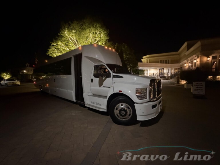 White luxury party bus at night with "Bravo Limo" logo